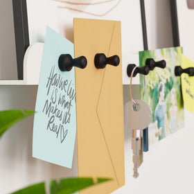 Smart&Cool magnets holding more than ten sheets of paper on a fridge.