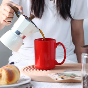 Smilatte mug on a desk with tea and cocoa, versatile beverage choice.