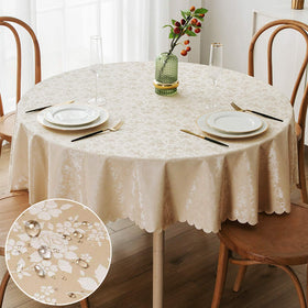 Smiry round beige table cloth, 70-inch round, with floral embossing and scalloped edge for elegant dining protection.