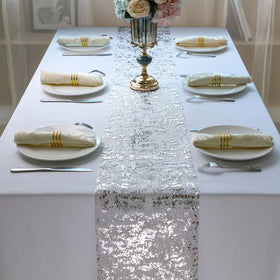 Snowkingdom wedding table decor with silver runner enhancing dining setup