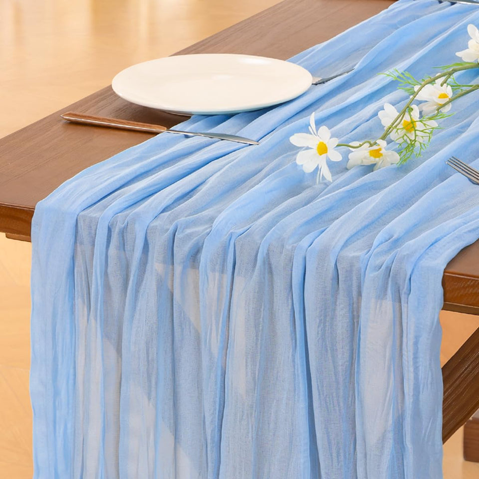 Socomi blue cheesecloth table runner draped over a wedding arch for a soft, romantic ambiance.