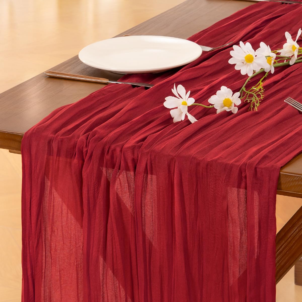 Socomi cheesecloth table runner at a wedding arch for elegant decor.