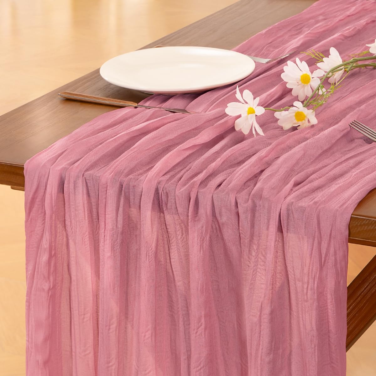 Socomi mauve summer cheesecloth table runner draped on a table for rustic elegance.