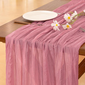 Socomi mauve summer cheesecloth table runner draped on a table for rustic elegance.
