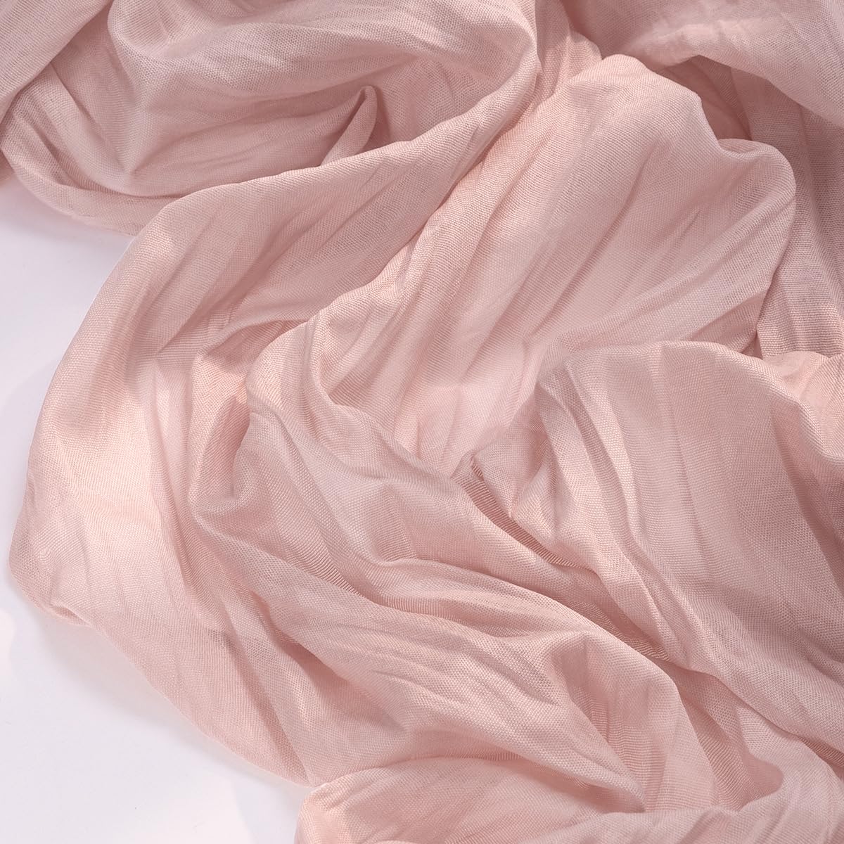 Socomi pink cheesecloth runner drapes over an arch for a dreamy ceremony backdrop