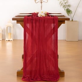 Socomi red cheesecloth runner on a festive dining table setup.
