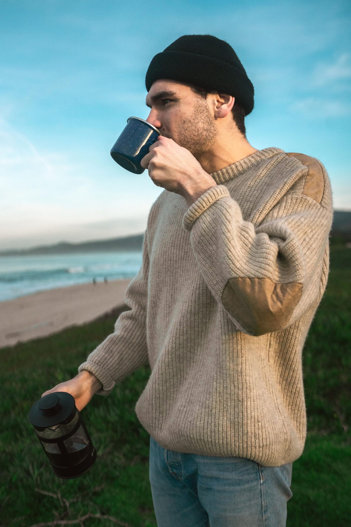 Stansport blue enamel mug in camping kit setup near tent.