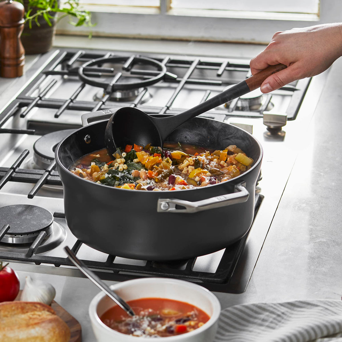 STAUB silicone ladle showing acacia wood handle for ergonomic grip