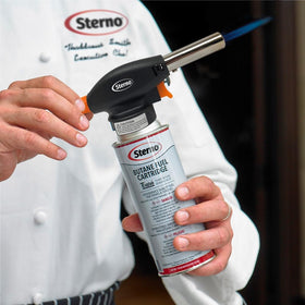 Sterno torch in a kitchen setup ready for plating and finishing touches.