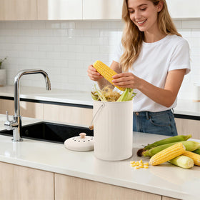 Sugoods compost bin with wooden grip on beige finish on counter