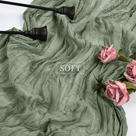 Sunnyline sage green cheesecloth table runner styled with candles and florals.