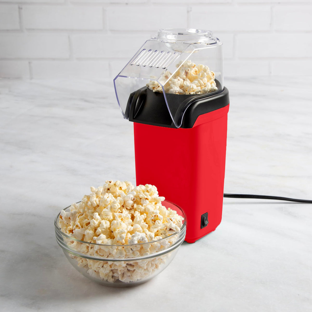 Tasty hot air popcorn popper counter-ready red on kitchen counter.
