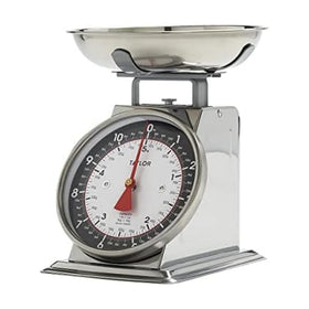 Taylor mechanical scale with removable bowl on a kitchen counter for precise ingredients.