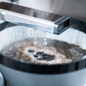 Technivorm Moccamaster KBT Stone Grey showing adjustable flow via the drip-stop brew-basket.