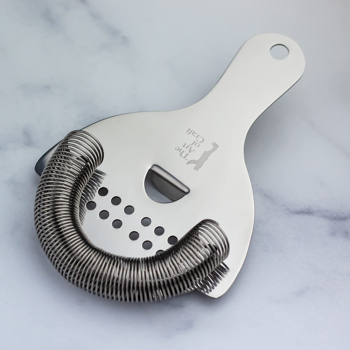 The Art of Craft Hawthorne Strainer in use, pouring smoothly from a shaker.
