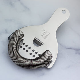 The Art of Craft Hawthorne Strainer in use, pouring smoothly from a shaker.