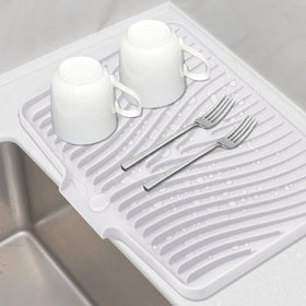 TIKNIK silicone drying mat on kitchen counter with built-in drain for quick air drying.