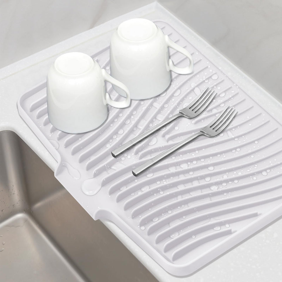 TIKNIK silicone drying mat on kitchen counter with built-in drain for quick air drying.