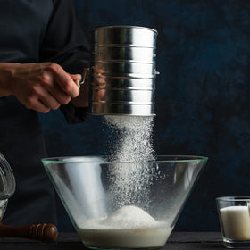 Toresano Flour Sifter in use dusting powdered sugar on pastries.
