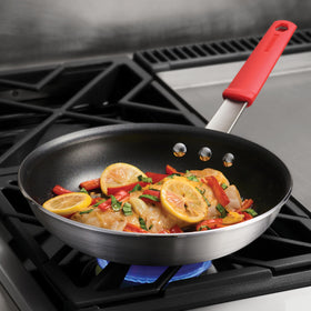 Tramontina Professional 10-inch nonstick fry pan handle close-up with red grip for controlled cooking.