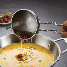 Ergonomic stainless steel handle on the Tramontina Utsava Tadka Pan for comfortable use.
