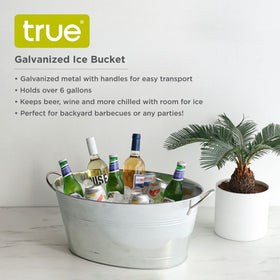 TRUE galvanized tub on a patio table during a gathering for beverages.