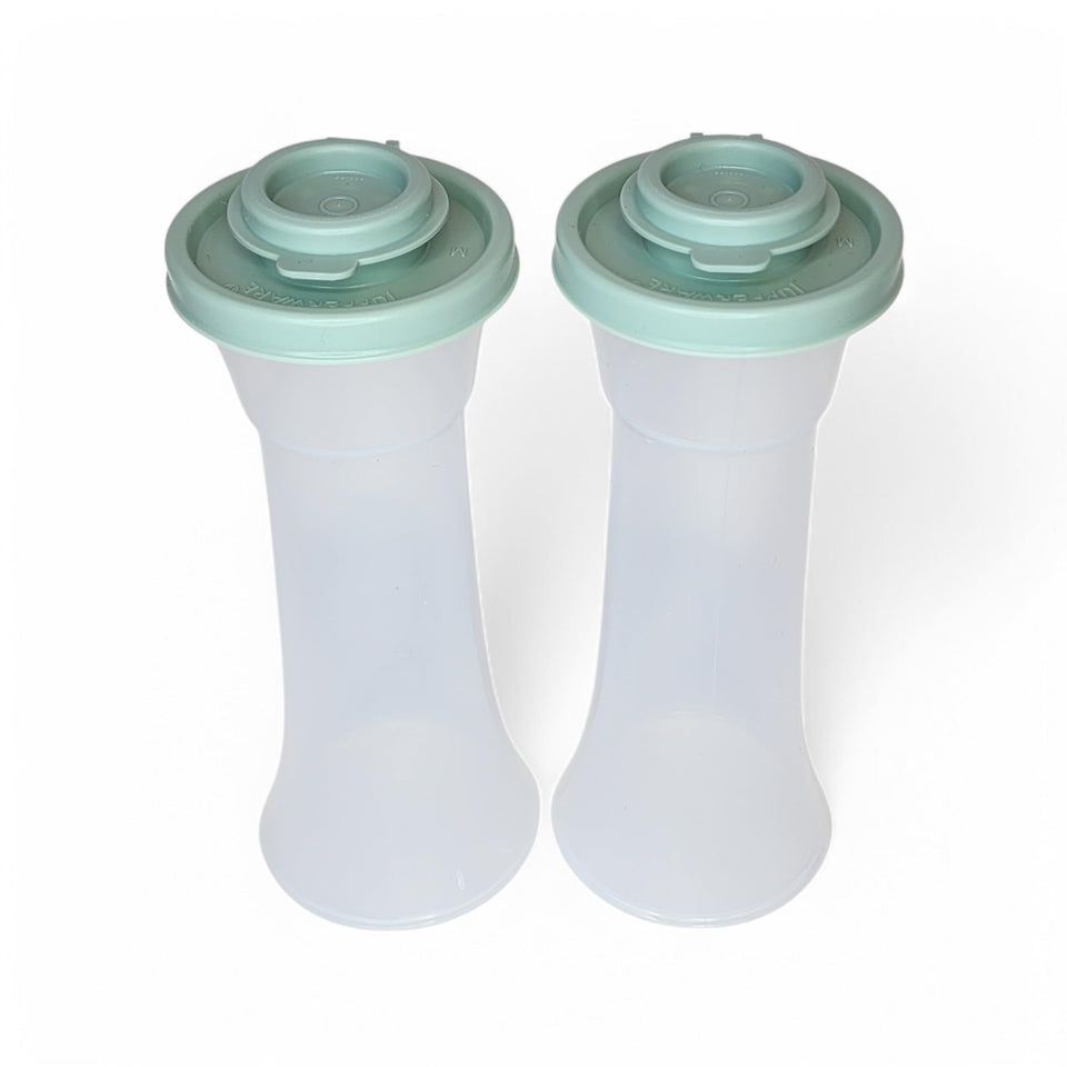 Tupperware large hourglass salt and pepper shakers in clear glass with sage green seal for fresher flavor.