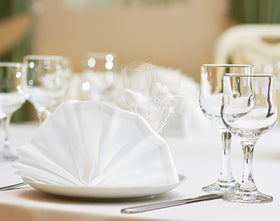 Utopia Home 17x17 inch napkins folded for elegant place settings.
