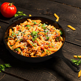 Utopia Kitchen cast iron pan sizzling with food to show browning capability