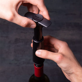 Vacuvin wine stopper gray in use on an opened bottle.