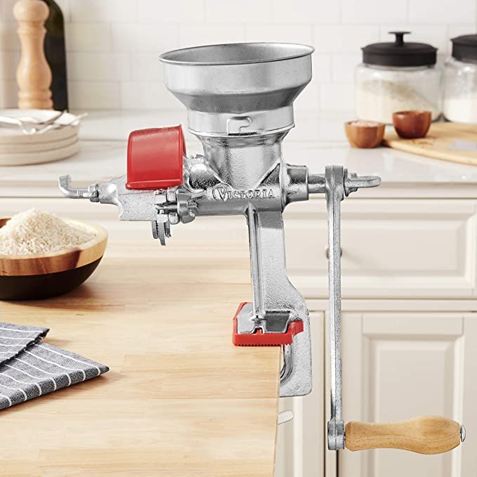 Victoria manual grain mill hand crank in action for versatile grinding.