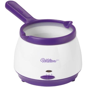 Wilton candy melts pot on the counter ready for dipping strawberries and pretzels.