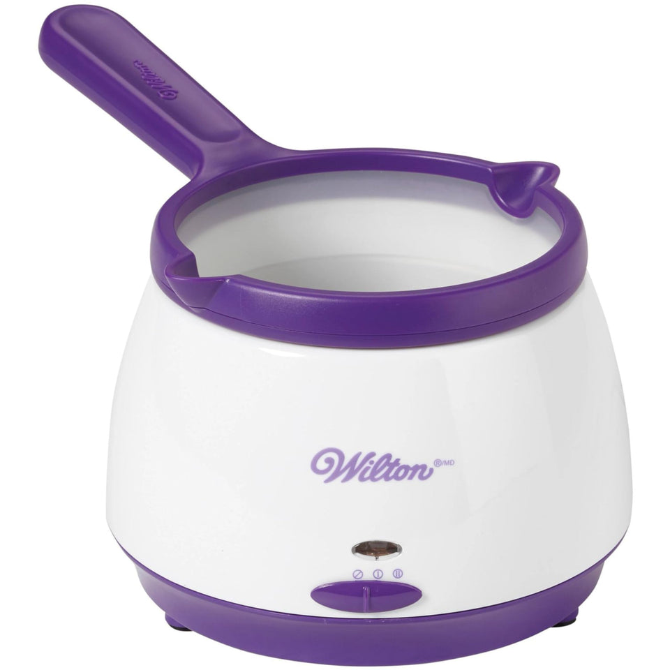 Wilton candy melts pot on the counter ready for dipping strawberries and pretzels.