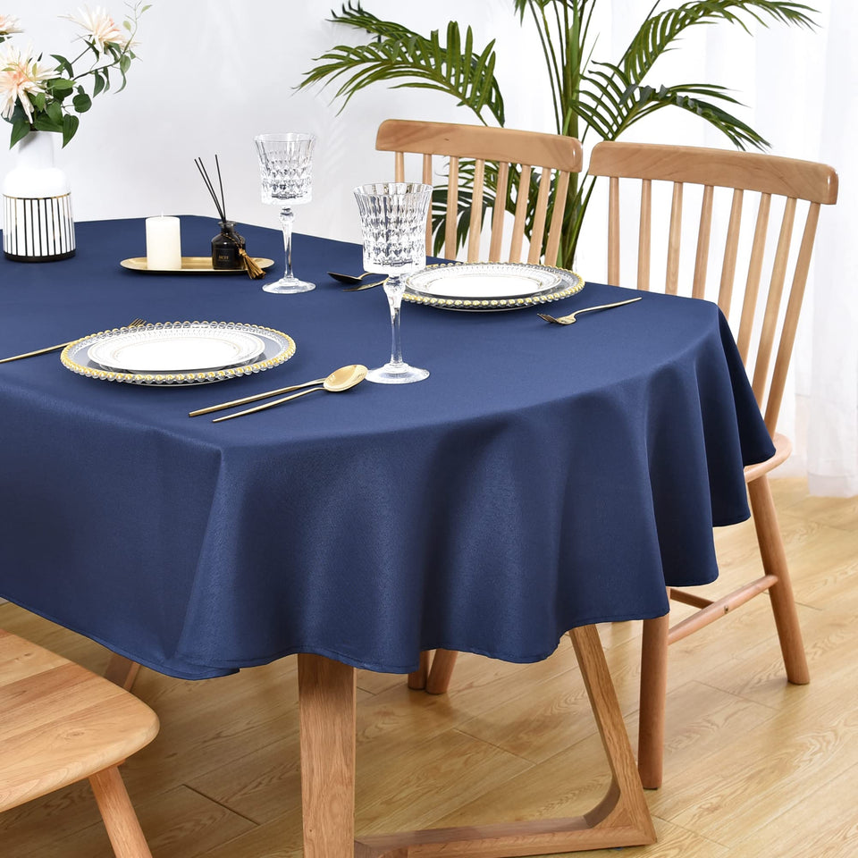 Wolkemer oval tablecloth in navy blue draped on dining table for an elegant meal