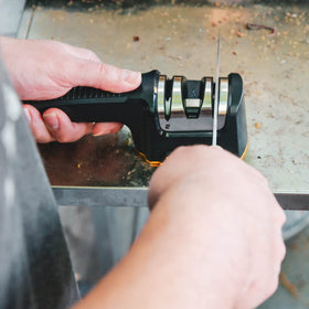 Compact Work Sharp Pull Through stored beside BBQ kit for travel use.