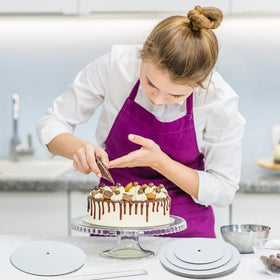 Worldity parchment sheets protect surfaces during cake assembly.