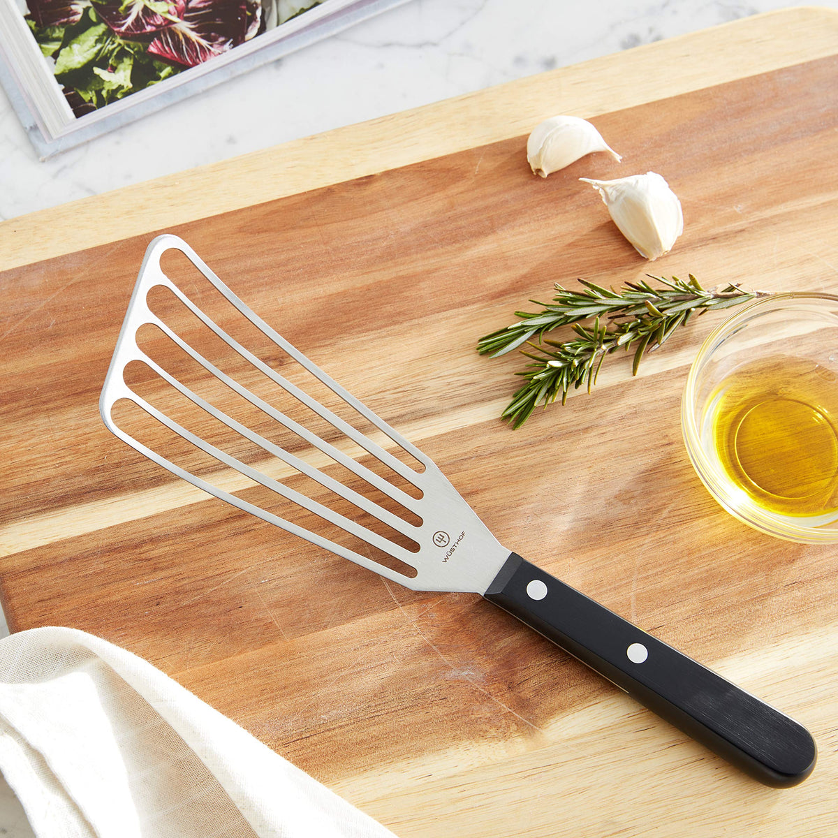 WÜSTHOF Gourmet spatula handle with rivets offers durable control for steady stirring.