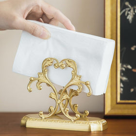 Brass napkin dispenser on kitchen counter with sturdy upright design