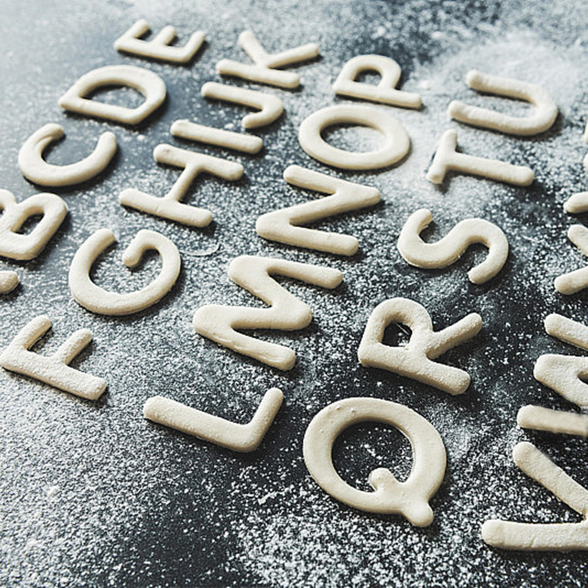Yomfut alphabet cookies on baking sheet showcasing easy letter-based designs.