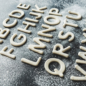 Yomfut alphabet cookies on baking sheet showcasing easy letter-based designs.