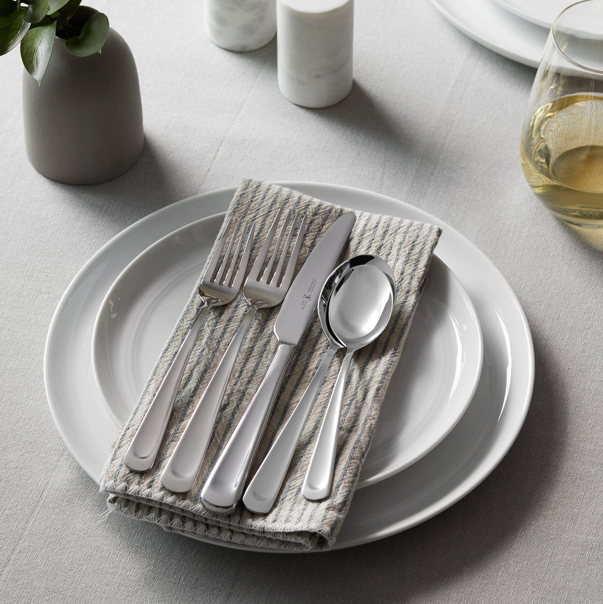 ZWILLING Silvano dinner fork and salad fork resting beside a plate.